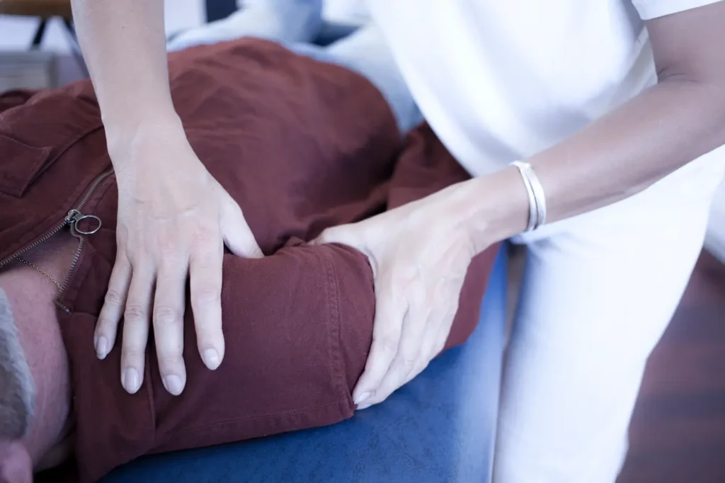Contact manuel léger et précis au niveau de l’épaule pendant une séance de Body Stress Release.